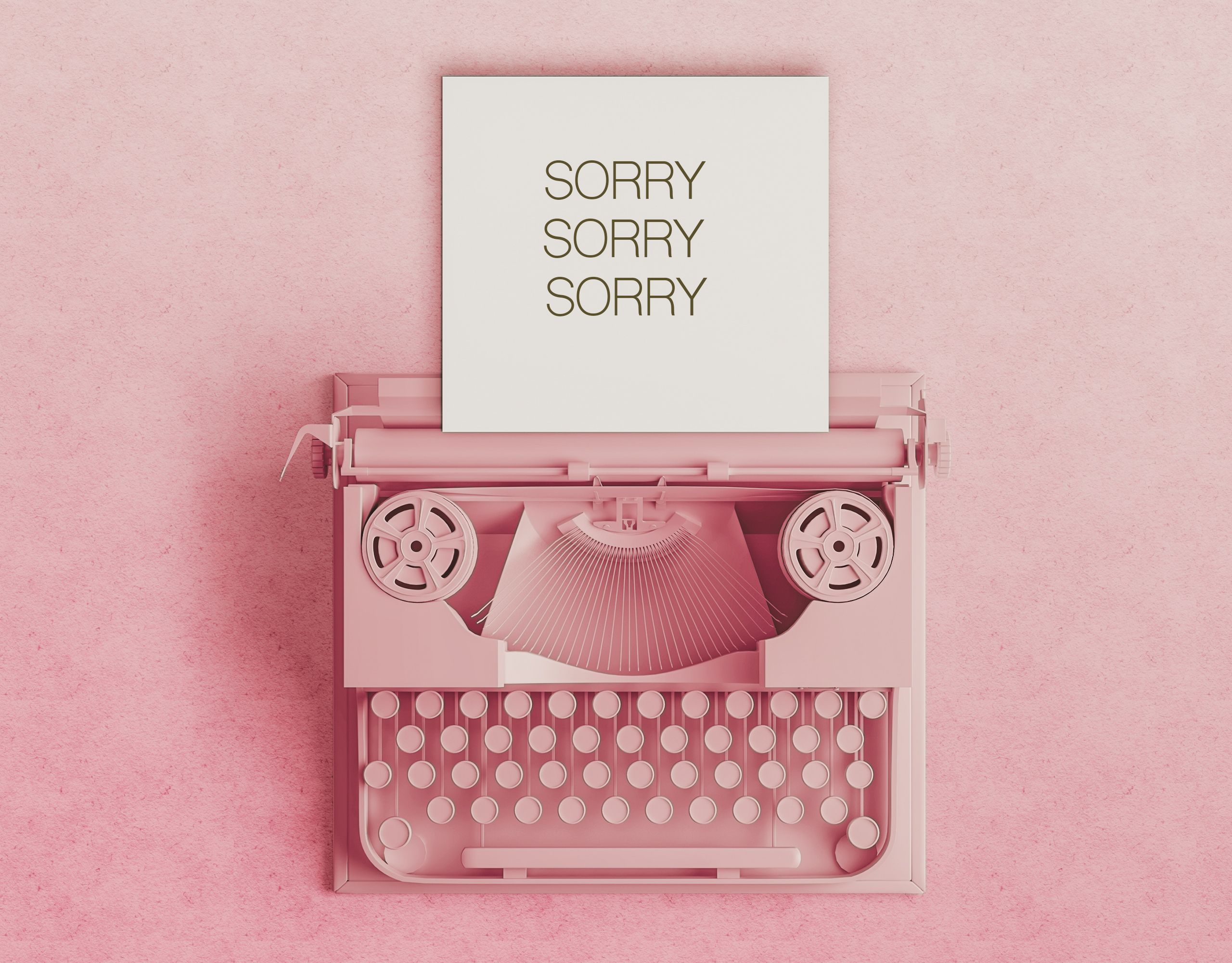 sorry message in paper  on feminine desktop with coffee cup, pink pen and candles