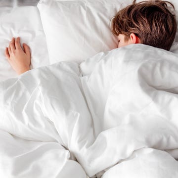 A sound asleep boy lying on a bed a sound asleep boy lying on a bed