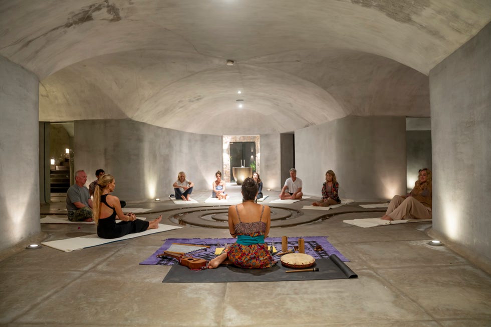 meditation session in a minimalistic circular room with participants organized in a circle around a center