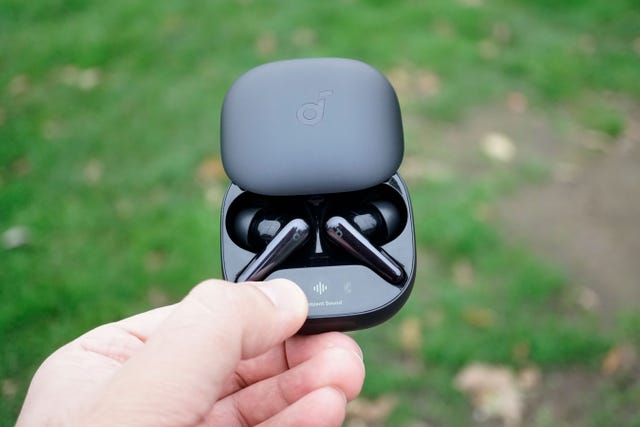 soundcore liberty 4 pro wireless earbuds in their charging case held by a hand outdoors
