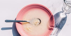 soup in a pink dish with shadows and noodles pasta