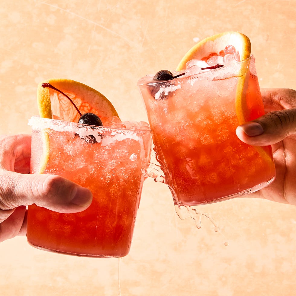 rocks glasses filled with ice, grapefruit juice, sour cherry juice, and tequila, garnished with grapefruit wheels and maraschino cherries