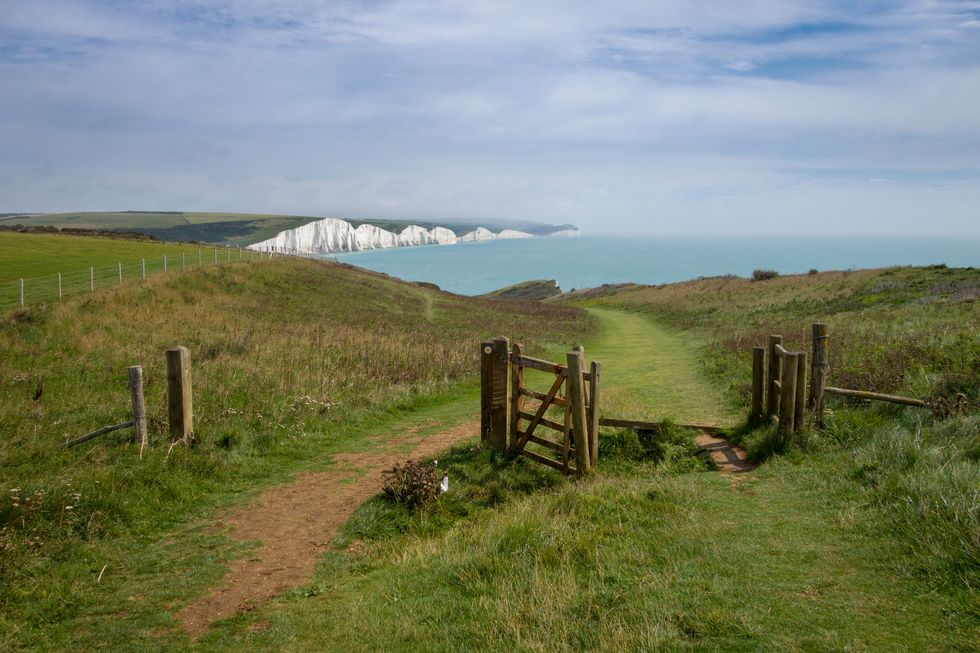 looking towards cuckmere haven on the vanguard way footpath with birling gap and the seven sisters in the distance