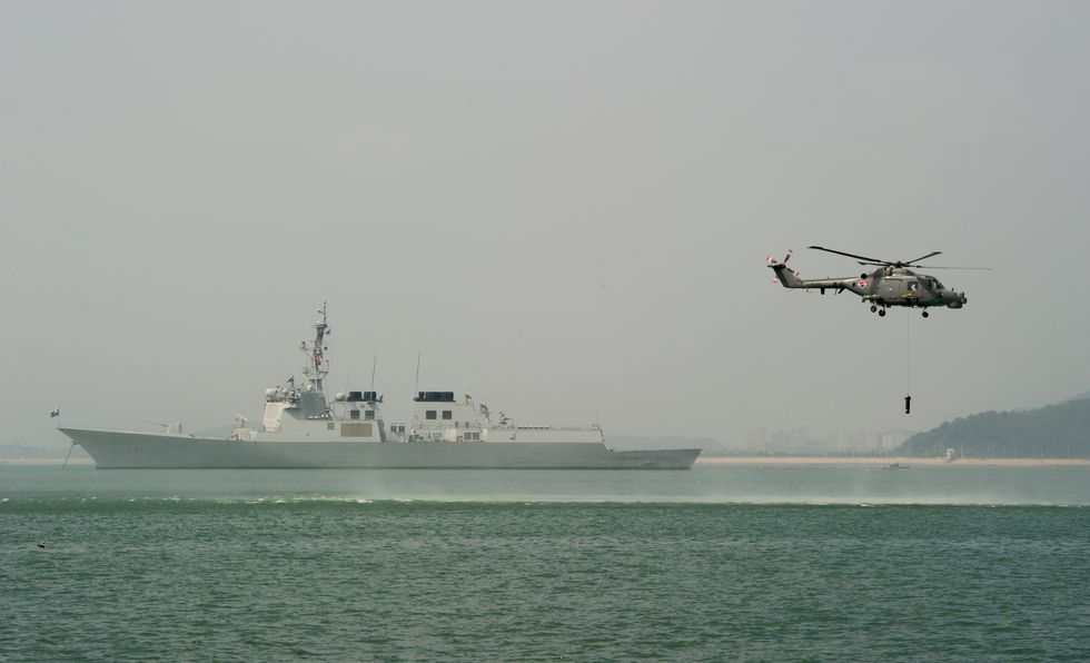 south korean navy submarine and a helicopter lowering a sonar device into the sea
