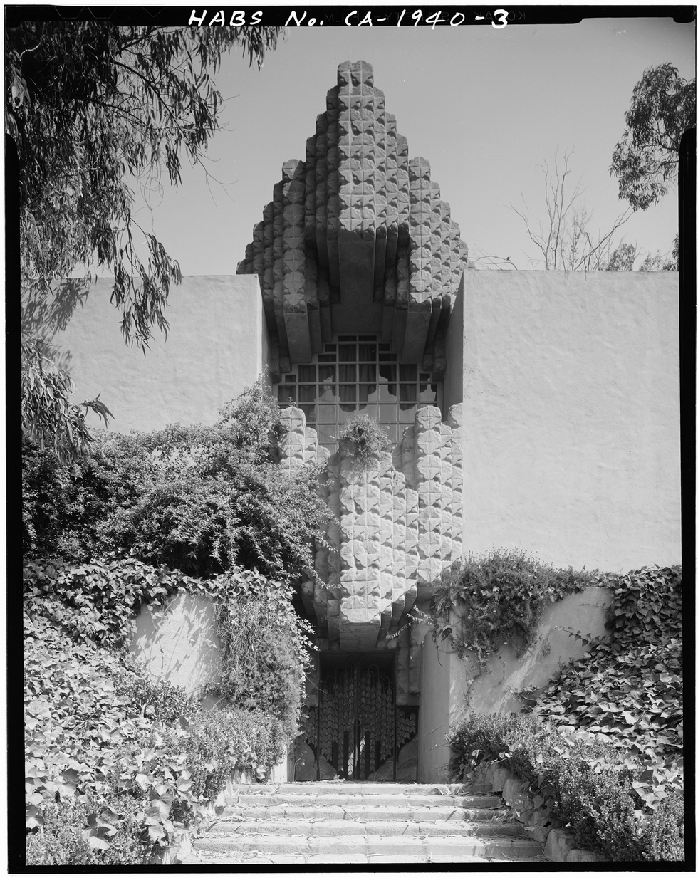 a stone building with stairs and bushes a stone building with stairs and bushes