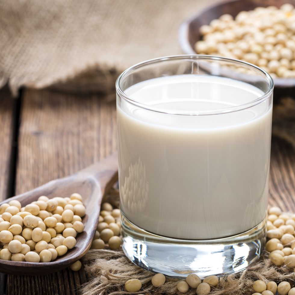 soy beans on a wooden table with a glass of milk on the side