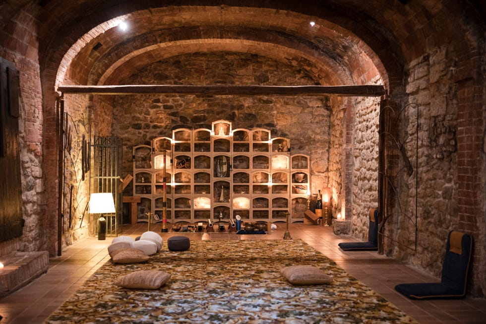 a room with a large stone floor and a large arched doorway