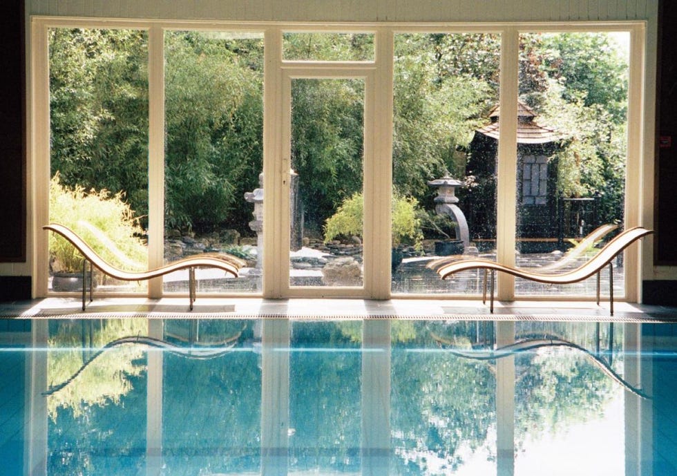 a pool with loungers and a garden view