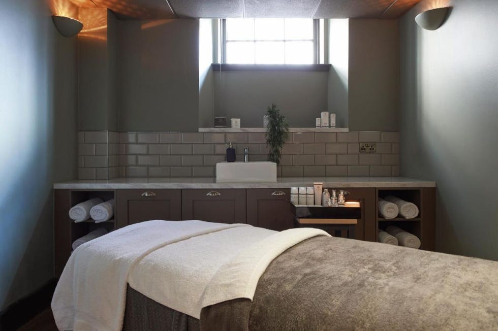 a spa treatment room with a bed and a sink