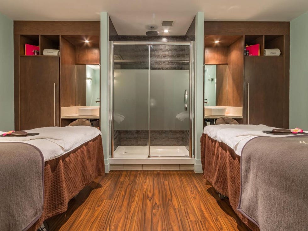 a treatment room with two beds and a glass door