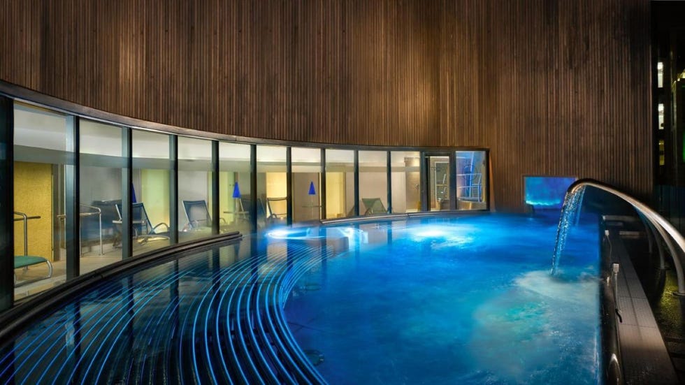 a swimming pool with a deck and glass walls