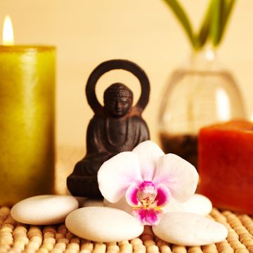 spa still life buddha statue and candles, orchid flower