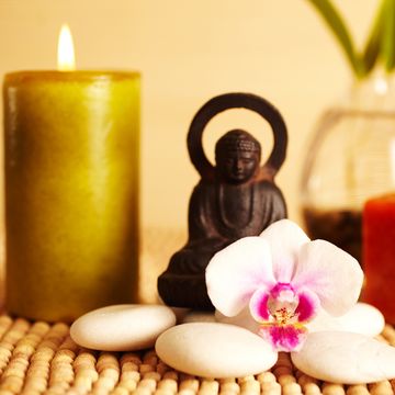 spa still life buddha statue and candles, orchid flower