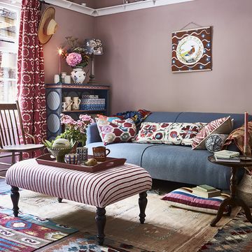 pink living room with blue sofa and antiques