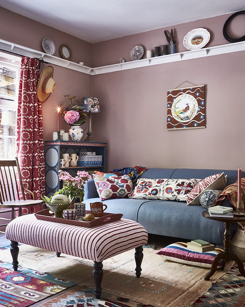 pink living room with blue sofa and antiques
