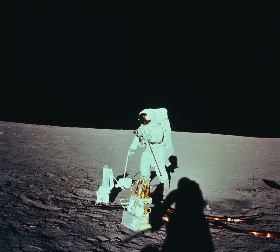 astronauta che schiera un pacchetto di esperimenti Apollo sulla superficie lunare