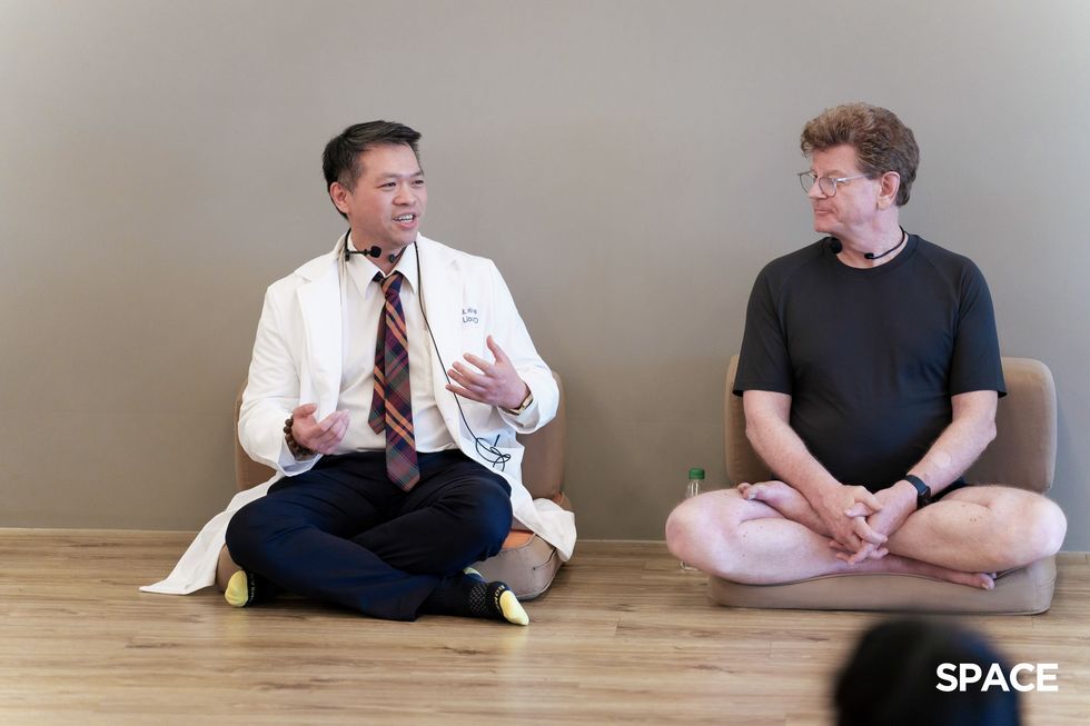 a man sitting on the floor next to a man sitting on the floor