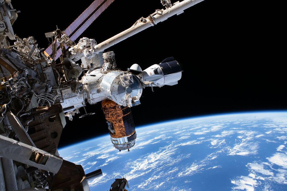 Uiterst rechts is het ruimtevaartuig Crew Dragon van SpaceX te zien terwijl het op 1 juli is aangekoppeld aan het internationale ruimtestation Het ruimtevaartuig bracht NASAastronauten Doug Hurley en Bob Behnken naar het ruimtestation nade lancering op 30 mei 2020 Het was voor het eerst sinds 2011 dat er weer mensen vanaf Amerikaans grondgebied naar de ruimte gingen Tijdens hun 63 dagen durende verblijf aan boord van de ISS namen de twee astronauten net als NASAastronaut Chris Cassidy en de Russische kosmonauten Anatoly Ivanishin en Ivan Vagner veel fotos van de bemanning die aan het werk was en van de aarde