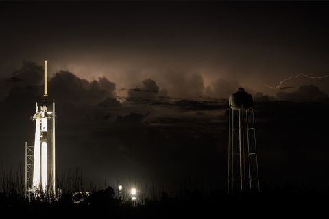Een dag vr de lancering zorgt weerlicht ervoor dat de hemel achter het lanceerplatform 39A met daarop de SpaceXraket Falcon 9 en de ruimtecapsule Crew Dragon wordt verlicht