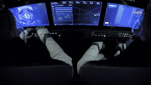 Foto waarop de cockpit van de SpaceXcapsule Crew Dragon en de NASAastronauten Doug Hurley en Bob Behnken zijn te zien kort nadat de capsule met succes is aangekoppeld aan het ISS
