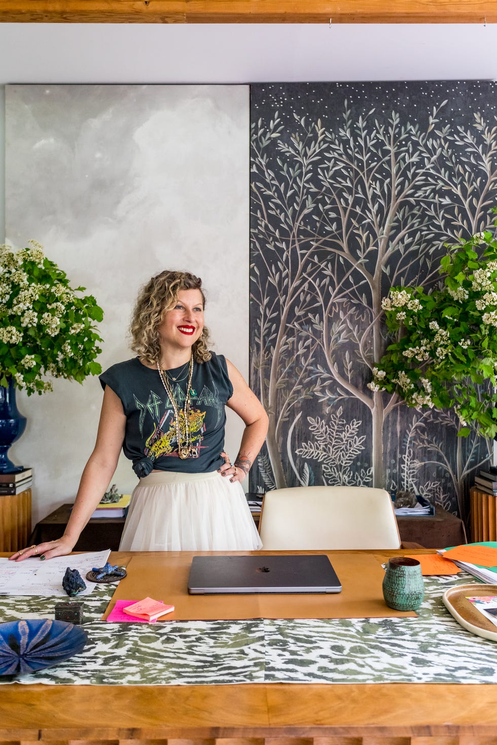 a modern workspace featuring a wooden desk with a laptop and decorative items