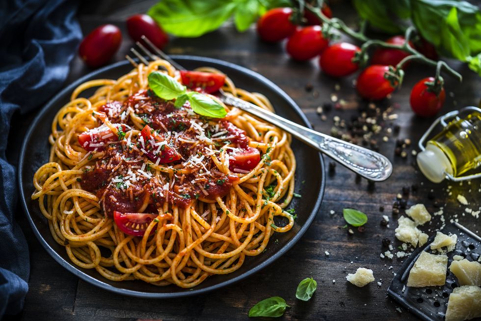 spaghetti with tomato sauce shot on rustic wooden table