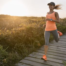 spain, aviles, young athlete woman running along a coastal path at sunset