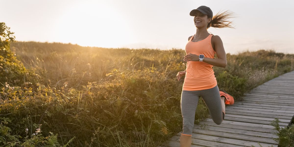 spain, aviles, young athlete woman running along a coastal path at sunset