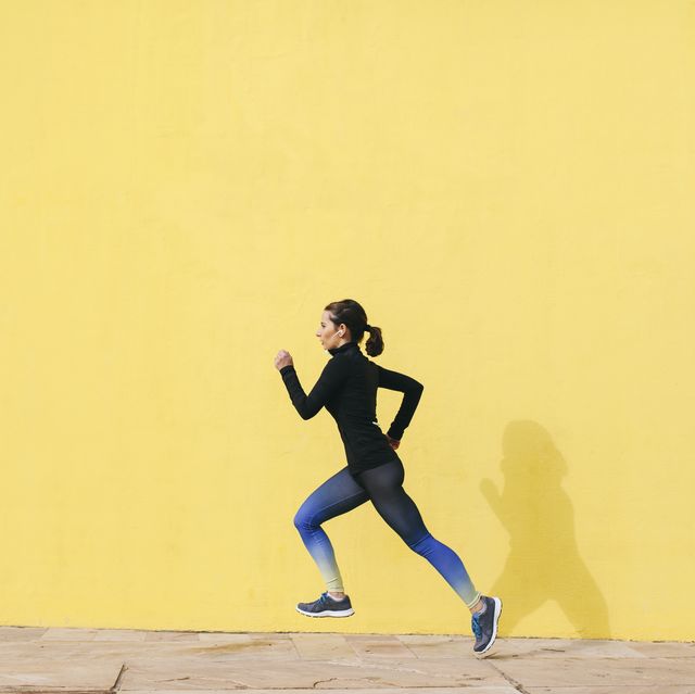 spain, barcelona, jogging woman in front of yellow wall