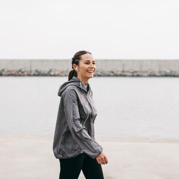 spain, barcelona, jogging woman with headphones at harbour