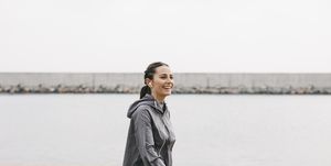 spain, barcelona, jogging woman with headphones at harbour