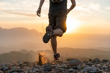 spain, barcelona, natural park of sant llorenc, man running in the mountains at sunset
