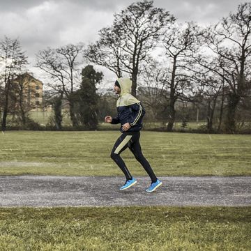 spain, man running in park in rainy weather