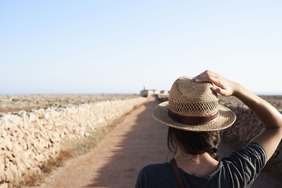 Spain, Menorca, back view of single traveller wearing straw hat