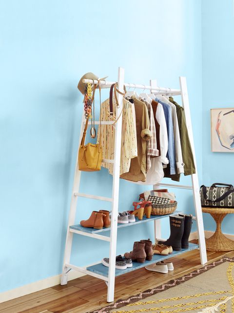 white ladder clothing rack against blue wall