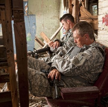 special ops military soldier resting in an abandoned house