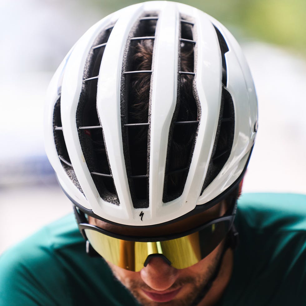 cyclist wearing a white helmet and sunglasses focusing on performance