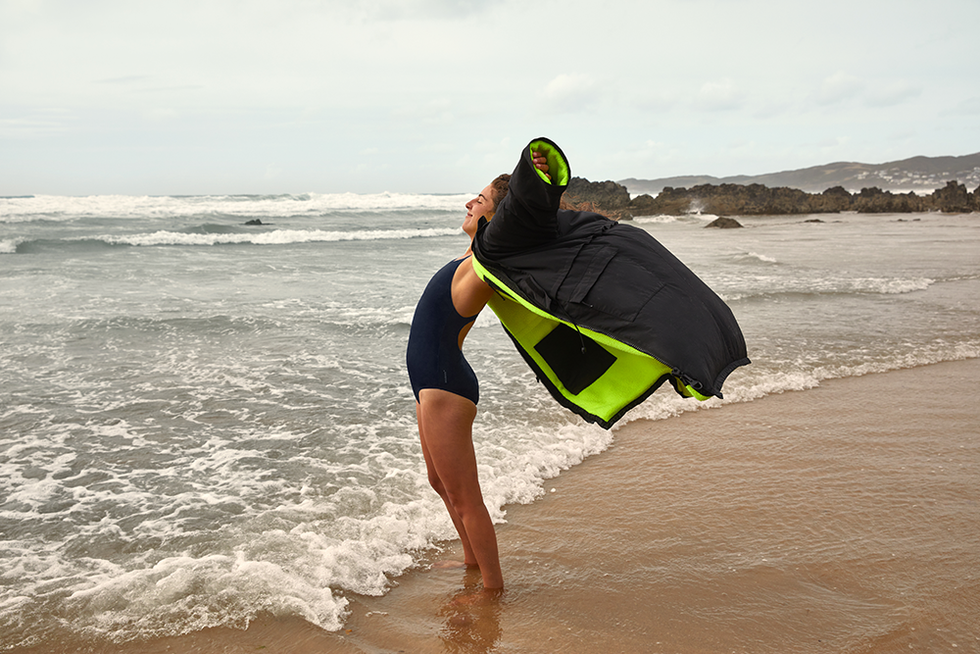 a person carrying a surfboard on a beach