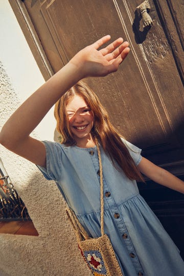 a person smiling and holding the hand up