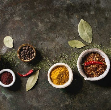 Spices seasoning and herbs variety in ceramic bowls. Different ground peppers, chili pepper, turmeric, bay leaf, cinnamon over dark metal background. Flat lay, space. Cooking concept Spices seasoning and herbs variety in ceramic bowls. Different ground peppers, chili pepper, turmeric, bay leaf, cinnamon over dark metal background. Flat lay, space. Cooking concept