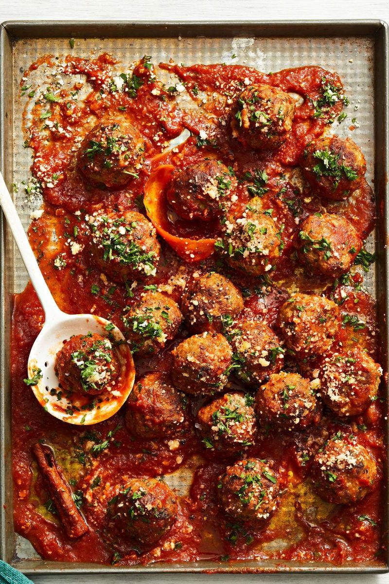 sausage meatballs with red sauce on a sheet pan