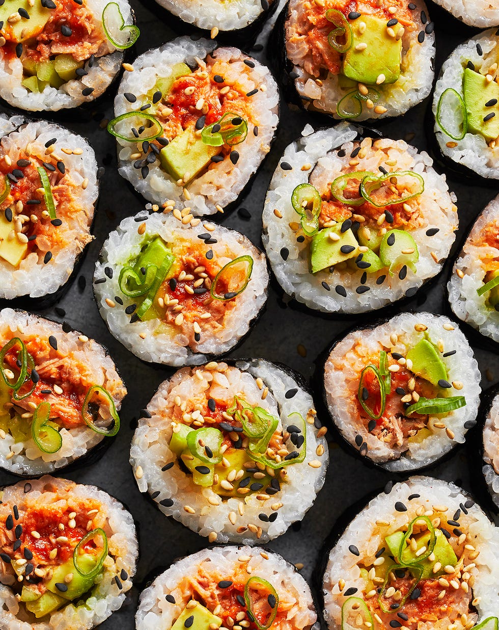 spicy tuna roll with scallions and sesame on top