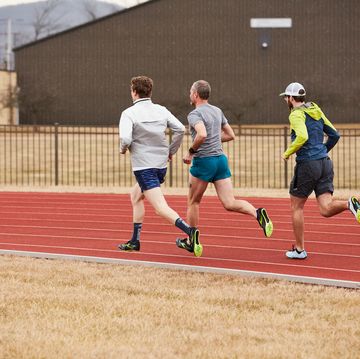 a group of men running Grey on a track
