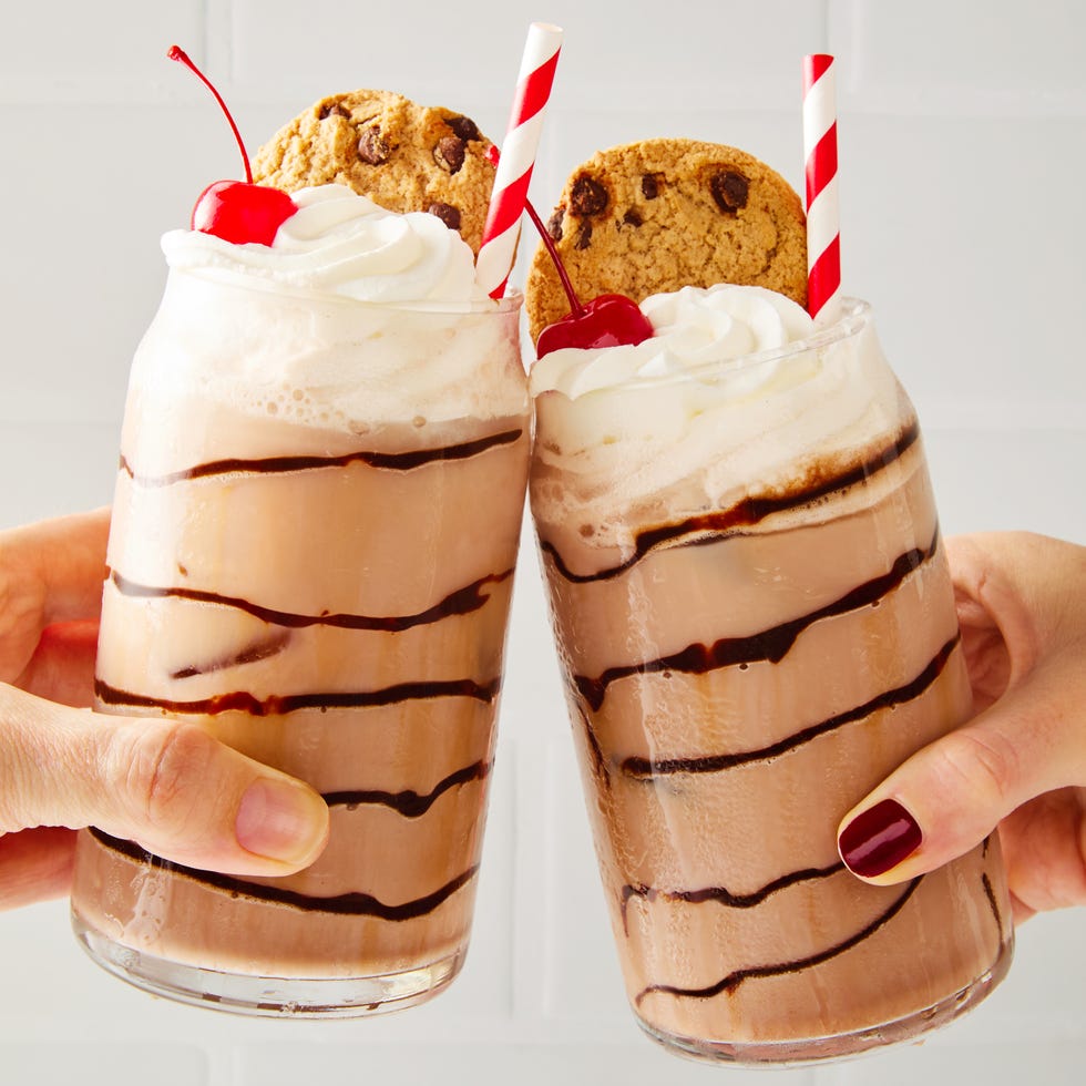 chocolate egg cream topped with whipped cream, a cherry, and a chips ahoy cookie