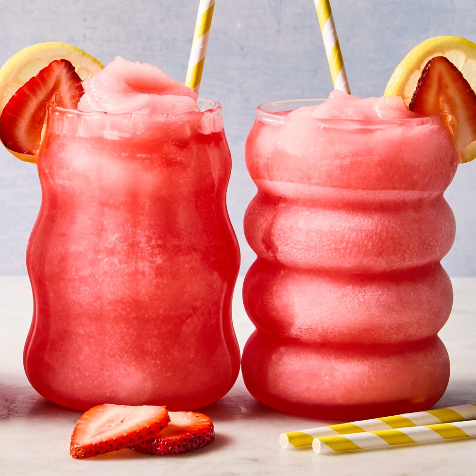 spiked pink lemonade slushies with sliced strawberries and lemon