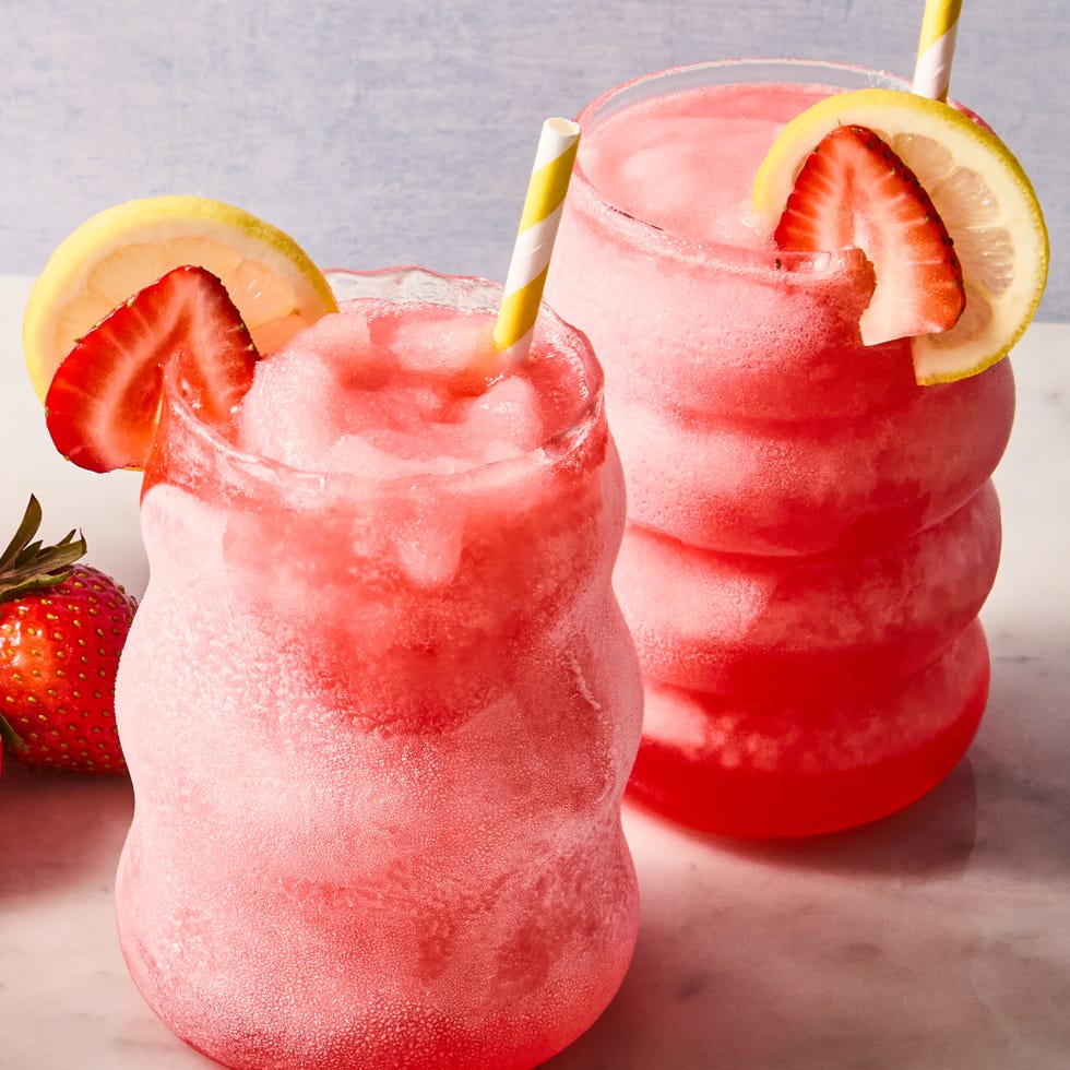 spiked pink lemonade slushies with sliced strawberries and lemon