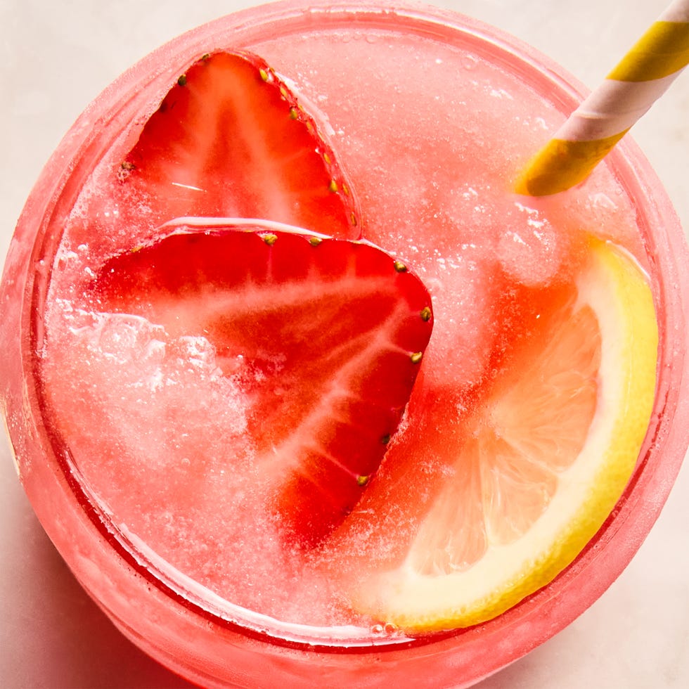 spiked pink lemonade slushies with sliced strawberries and lemon