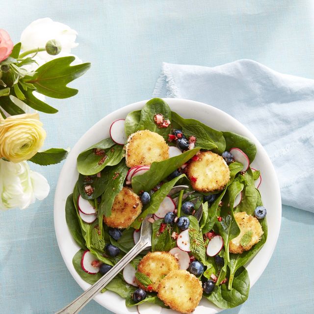 spinach and mint salad with crispy goat cheese in a bowl