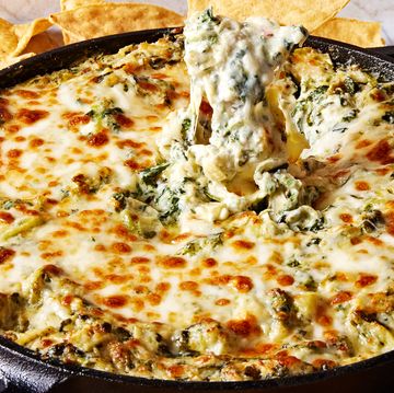 spinach artichoke dip in a cast iron skillet served with tortilla chips