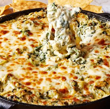 spinach artichoke dip in a cast iron skillet served with tortilla chips